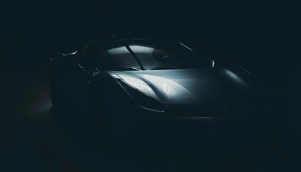 A black sports car sculpted by a single studio light